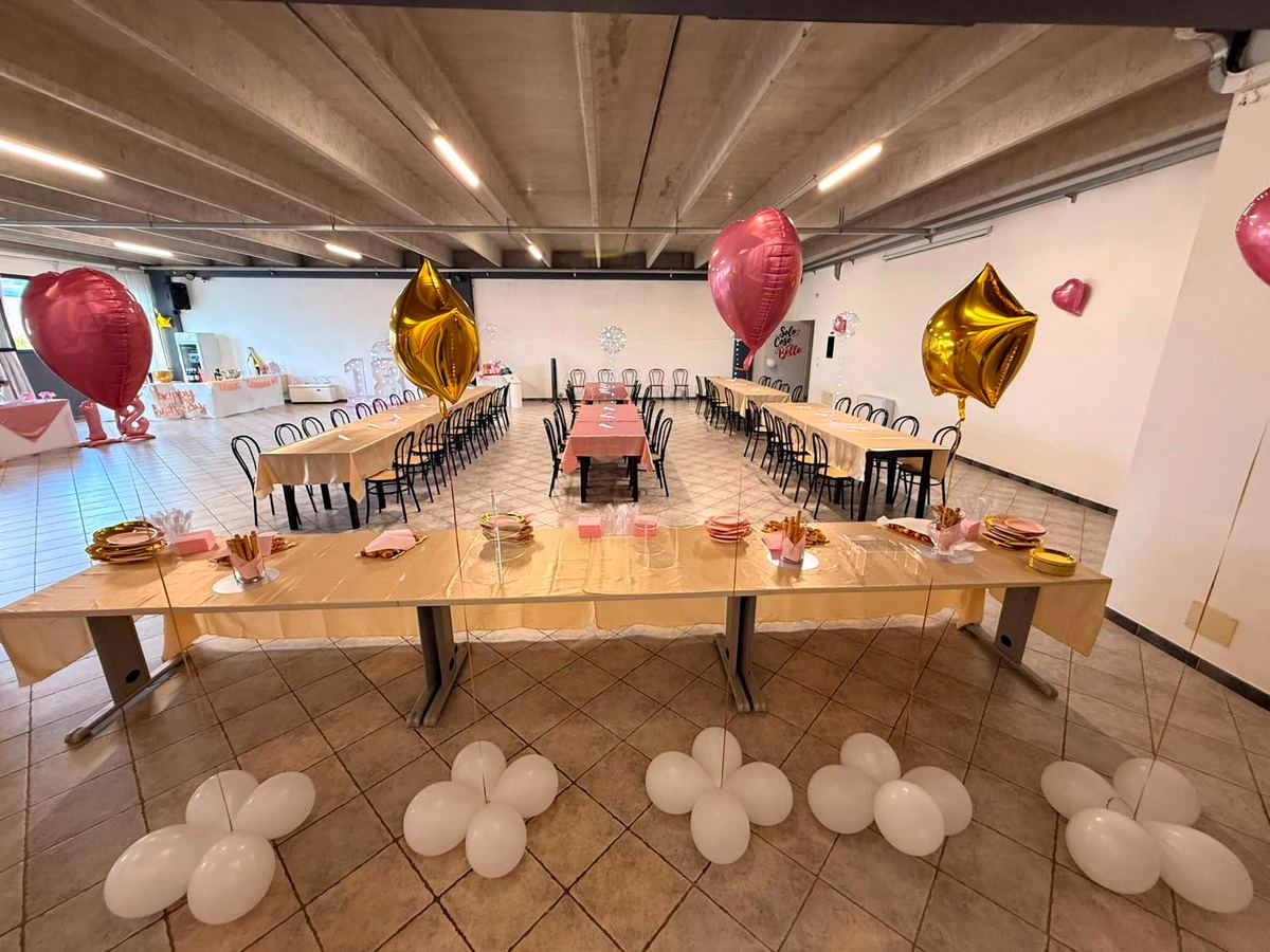 Tavolate apparecchiate per una festa, con palloncini a cuore e a stella