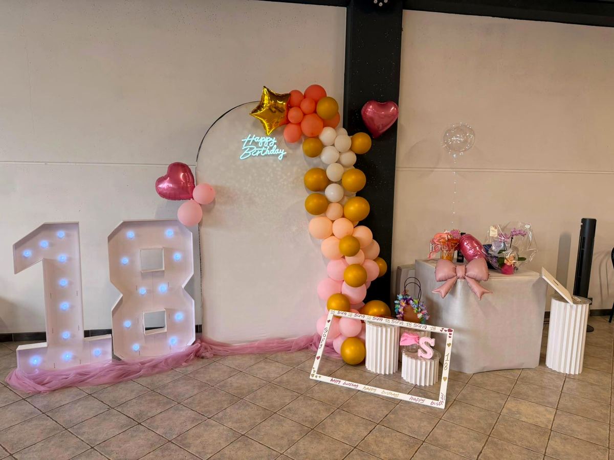 Allestimento per i 18 anni con numeri luminosi e arco di palloncini