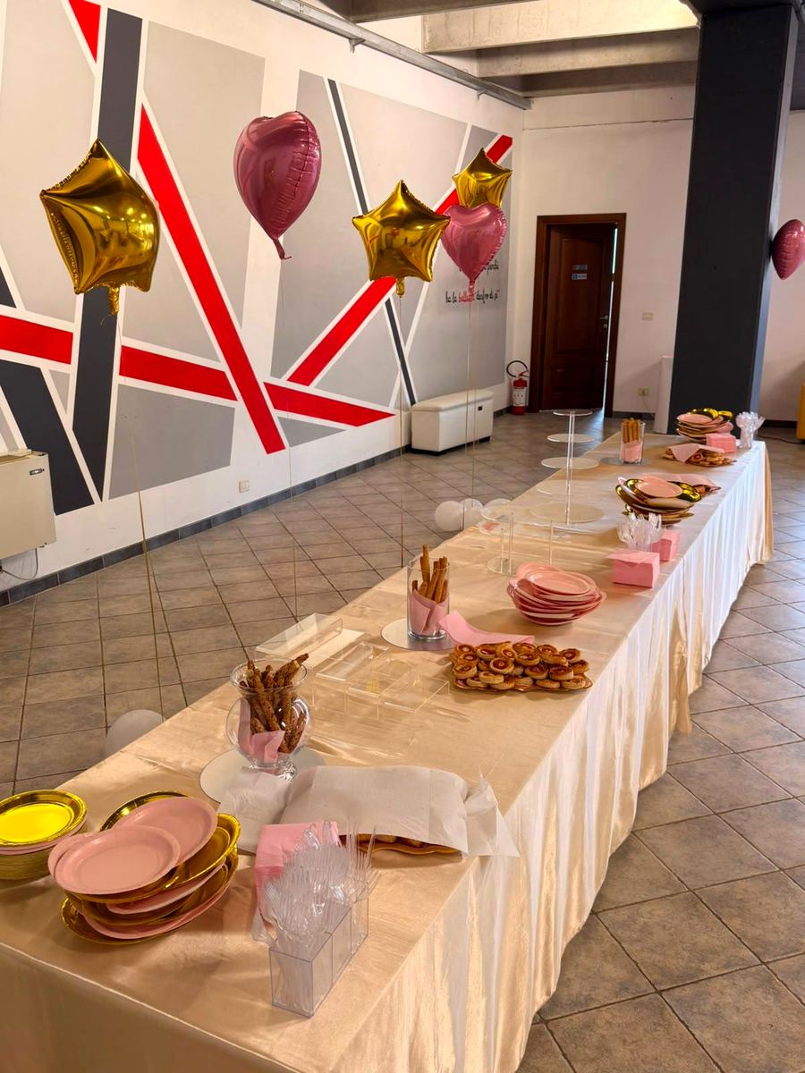 Tavolo lungo per il buffet con palloncini a cuore e parete a righe